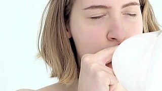 a young babe tries blowing and popping her first balloon in a looner session