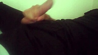 Horny guy in black pants moans while jerking his big cock after workout.