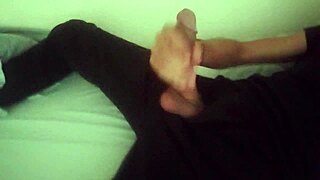 Horny guy in black pants moans while jerking his big cock after workout.