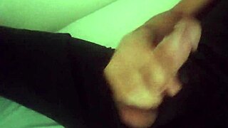 Horny guy in black pants moans while jerking his big cock after workout.