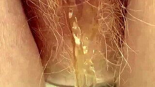 Redhead pees intensely through her hairy pussy