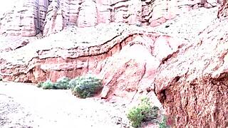 Teen with glasses reveals face during deep blowjob in canyon.