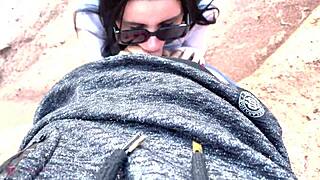 Teen with glasses reveals face during deep blowjob in canyon.
