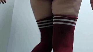 In the change room, a cheeky skinny babe tries on slutty tops topless and nude thigh high socks without panties.