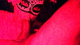 Masked girl sucks cock under red lights 😈
