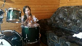 Wow, this teen is fucking her pussy with a big dildo right on the drumset!