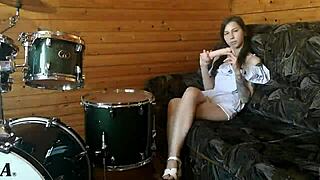 Wow, this teen is fucking her pussy with a big dildo right on the drumset!