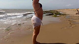 This morena Latina shakes her huge ass wildly while fingering pussy on sunny beach sand!
